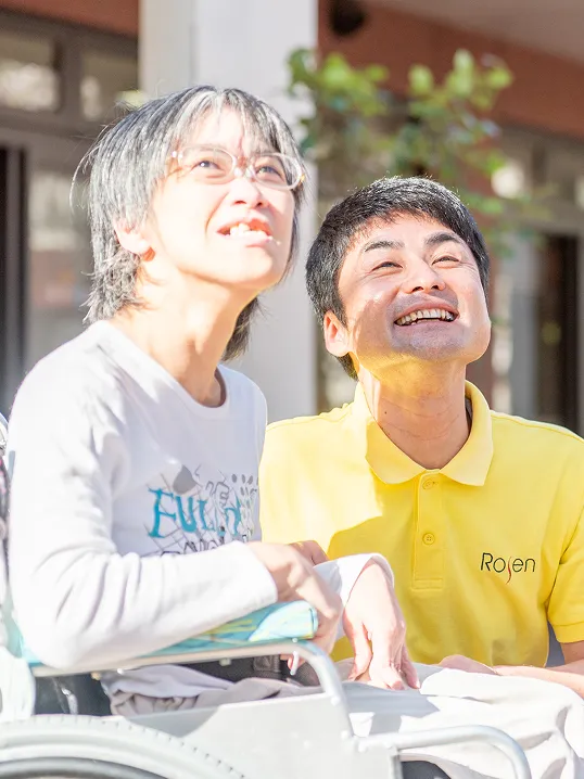 高齢のご利用者と笑顔で談笑する介護職員