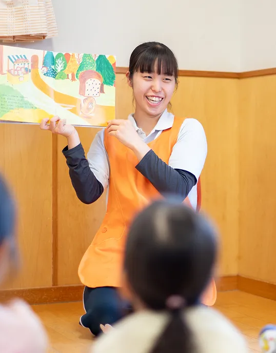 絵本を読み聞かせる保育士